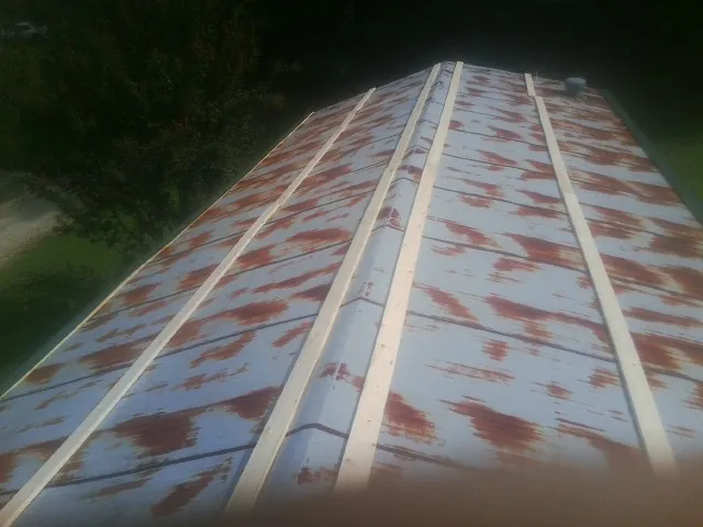Rusted metal roof panels with new wood purlins before replacement — Storm Damage Roof Repair in Wynantskill by Roofing Brothers