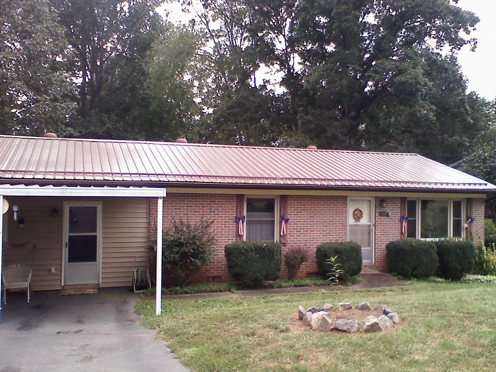Bronze metal roof and carport on a brick ranch home — Roof Repair work by our crew in Wynantskill